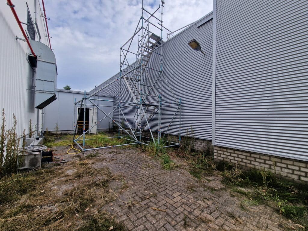 Bedrijfspand met containers en vervuilde buitenruimte